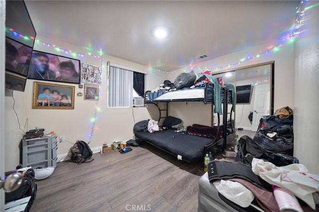 bedroom featuring visible vents, baseboards, and wood finished floors