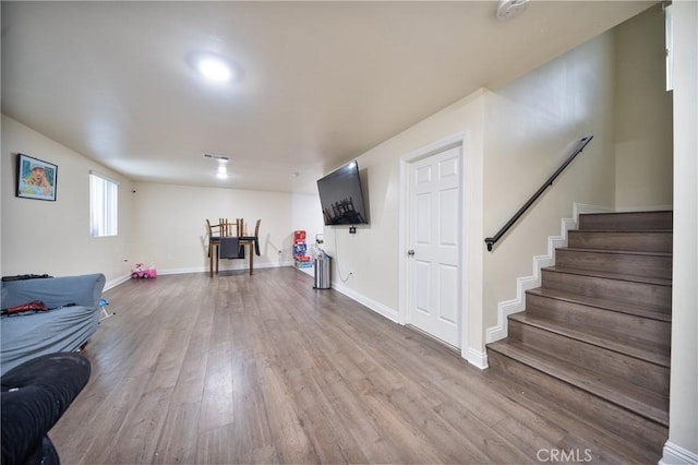 interior space with visible vents, baseboards, wood finished floors, and stairs