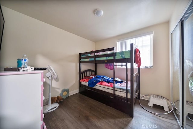 bedroom with a closet, baseboards, and wood finished floors