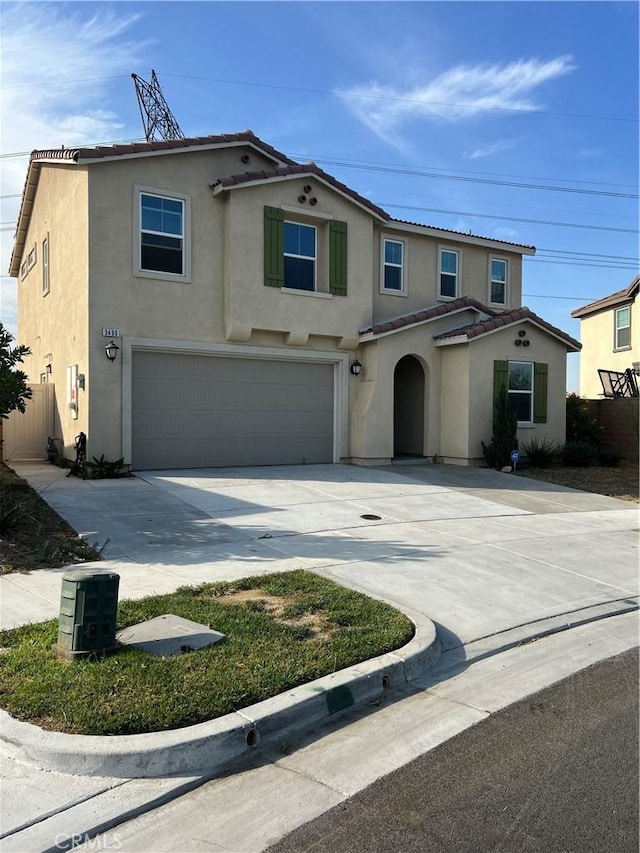 traditional home with a tiled roof, stucco siding, an attached garage, and concrete driveway