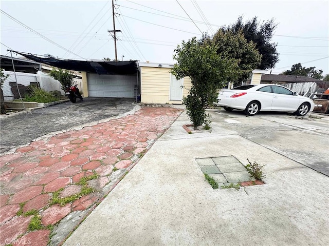 garage with a carport, fence, and driveway