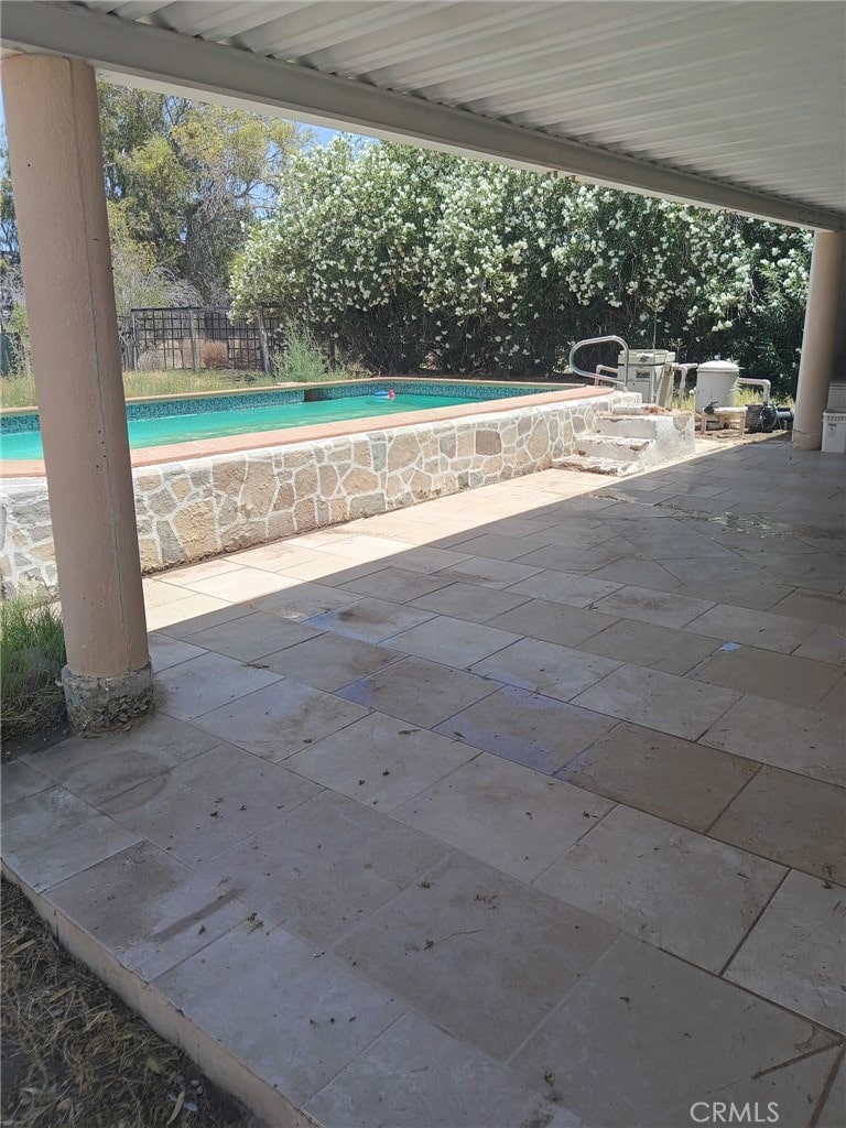 view of swimming pool featuring a patio, a fenced in pool, and fence