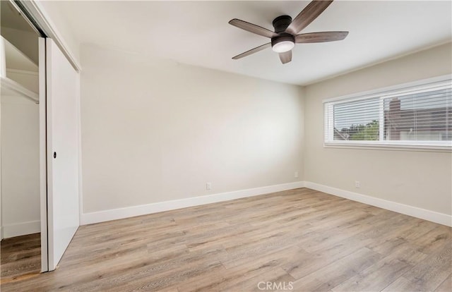 unfurnished bedroom with a closet, ceiling fan, baseboards, and light wood-style floors