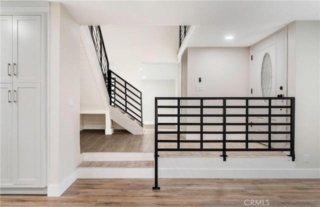 staircase featuring recessed lighting, baseboards, and wood finished floors