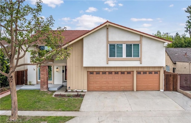 view of front of home featuring stucco siding, a front lawn, fence, concrete driveway, and an attached garage