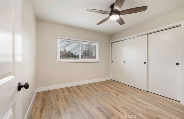 unfurnished bedroom with a closet, baseboards, and light wood finished floors