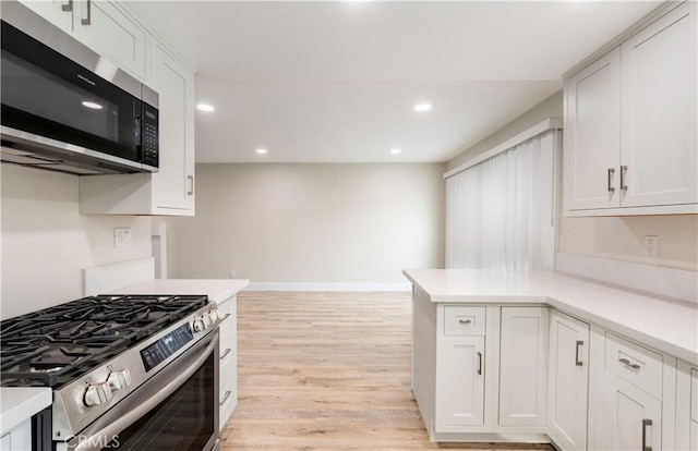 kitchen with recessed lighting, stainless steel appliances, white cabinets, and light countertops