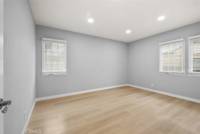 unfurnished room with recessed lighting, light wood-style flooring, and baseboards