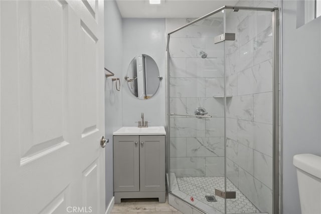 full bath featuring a shower stall, vanity, and toilet