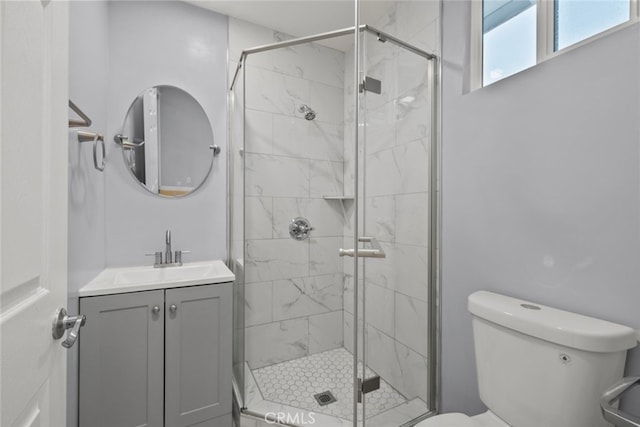 full bathroom with a shower stall, toilet, and vanity