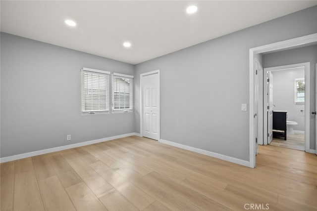 unfurnished bedroom with light wood-style flooring, recessed lighting, baseboards, and a closet