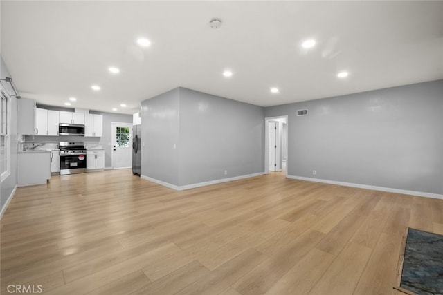 unfurnished living room with recessed lighting, visible vents, and light wood-style floors