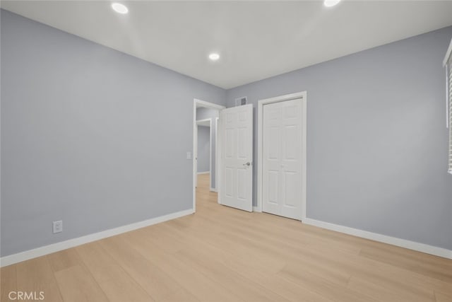 unfurnished bedroom with light wood-type flooring, visible vents, baseboards, and recessed lighting