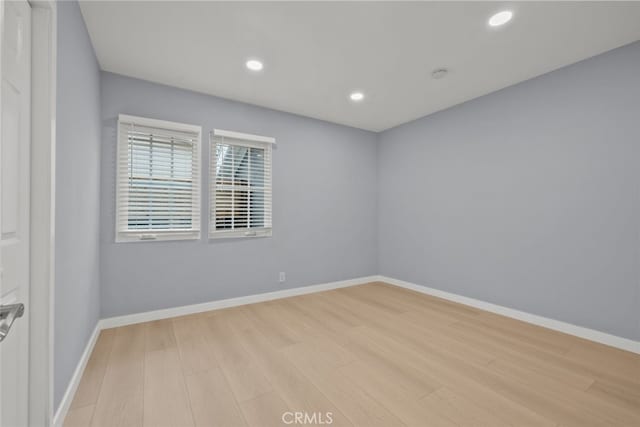 empty room with recessed lighting, baseboards, and wood finished floors