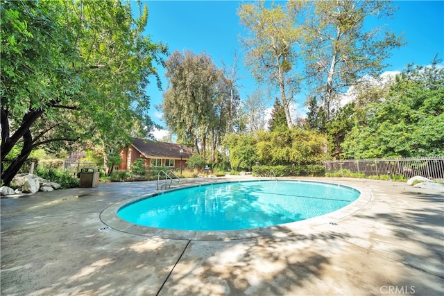 community pool featuring a patio area and fence