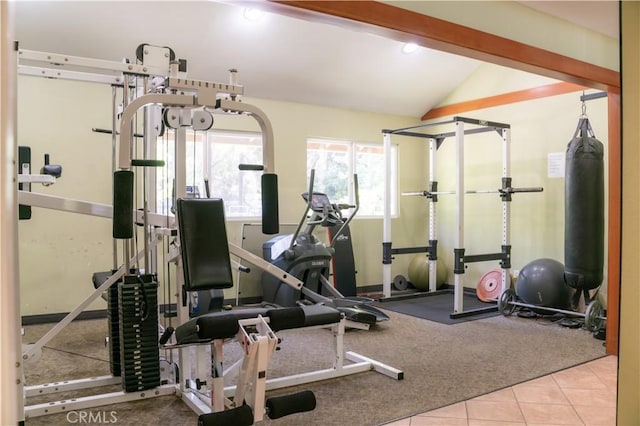 exercise room featuring tile patterned floors, carpet flooring, and vaulted ceiling