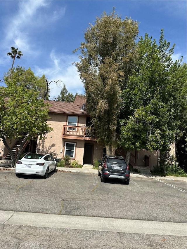 view of front of home with uncovered parking and stucco siding