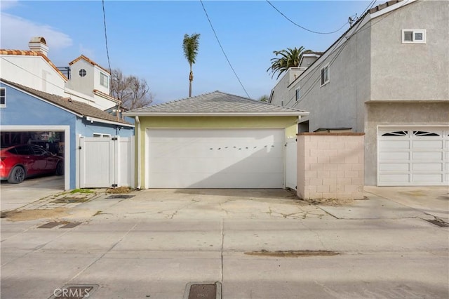 garage featuring fence and a gate