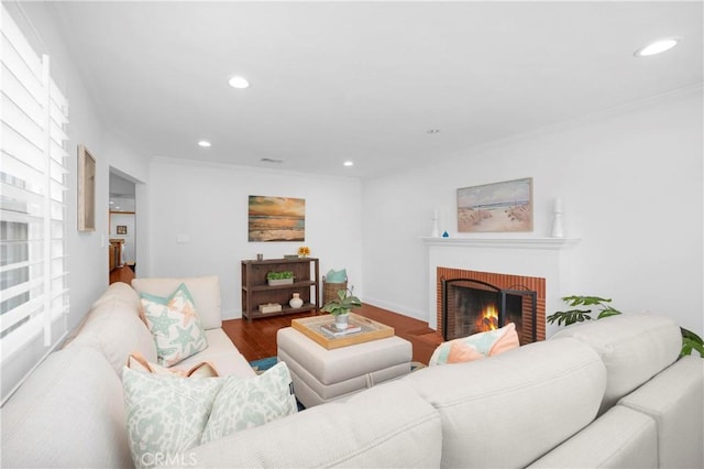 living area featuring wood finished floors, baseboards, a fireplace, recessed lighting, and ornamental molding