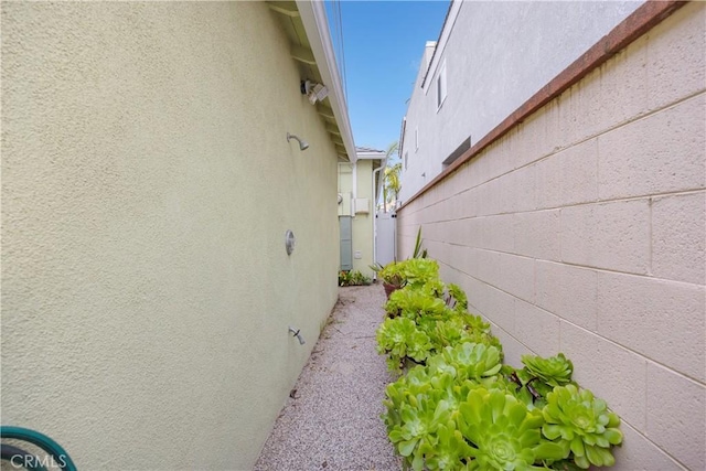 view of side of property featuring stucco siding and fence