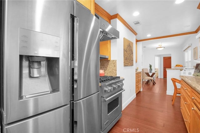 kitchen featuring visible vents, under cabinet range hood, ornamental molding, wood finished floors, and stainless steel appliances