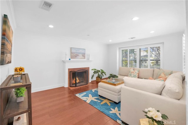 living room with visible vents, recessed lighting, a fireplace, and wood finished floors