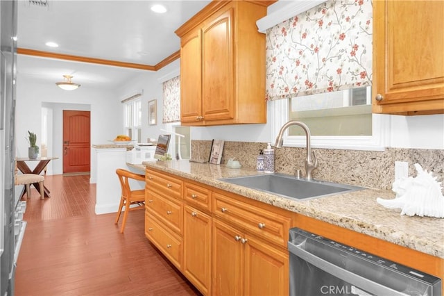 kitchen featuring a sink, light stone counters, stainless steel dishwasher, wood finished floors, and recessed lighting