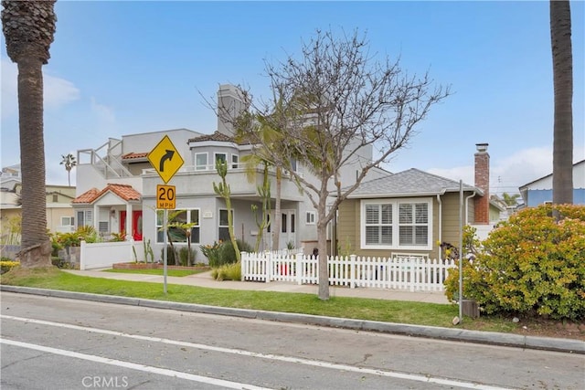 view of front of house featuring a fenced front yard and a chimney