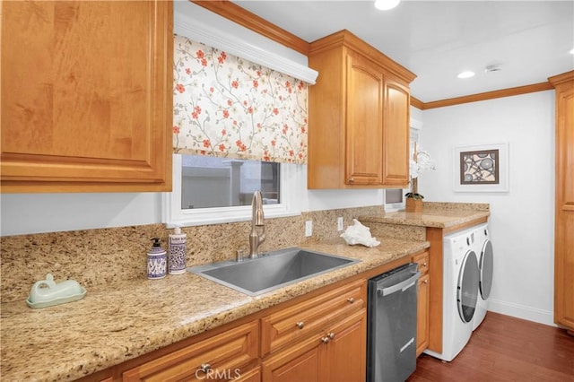 kitchen with dark wood-style flooring, ornamental molding, a sink, dishwasher, and washer and dryer