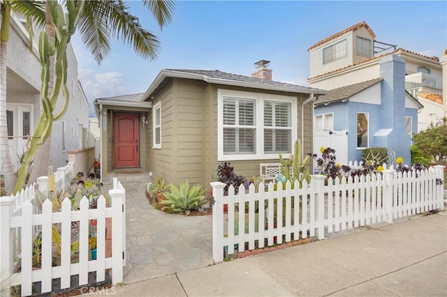 view of front of home with a fenced front yard and a chimney