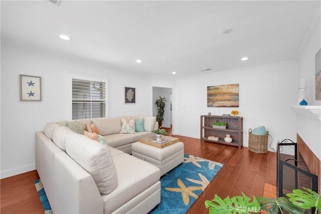 living area featuring a fireplace, crown molding, recessed lighting, and wood finished floors