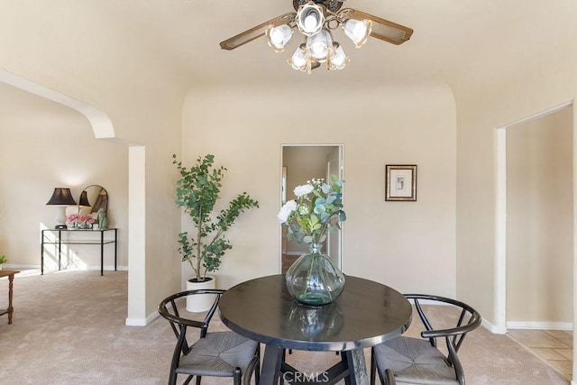 dining area with light colored carpet, baseboards, and a ceiling fan