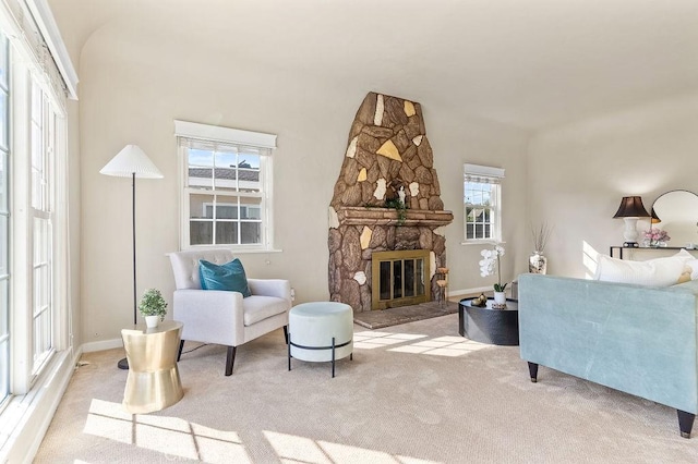 carpeted living room with a fireplace and baseboards