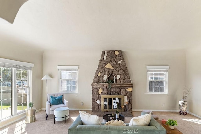 living area with a fireplace, baseboards, and carpet