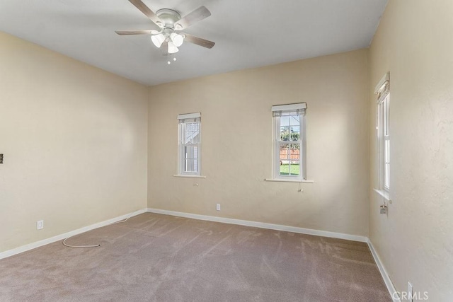 empty room featuring a ceiling fan, baseboards, and carpet floors