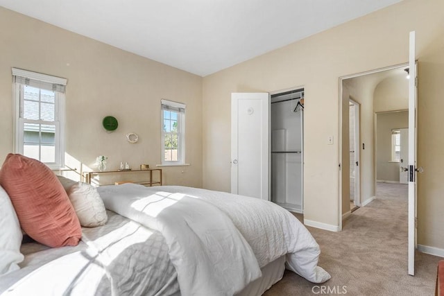 bedroom featuring baseboards, light colored carpet, and vaulted ceiling