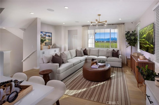 living room featuring recessed lighting, light wood-style floors, and an inviting chandelier