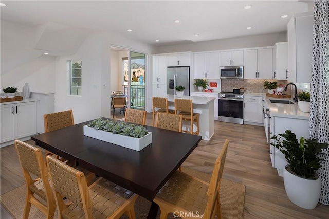 dining room with light wood finished floors and recessed lighting