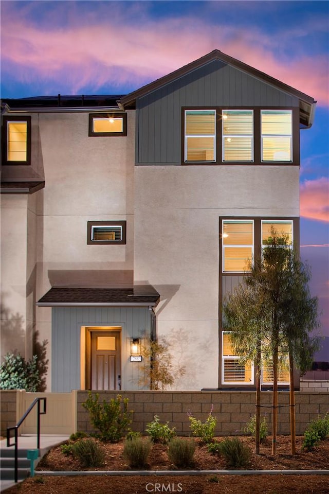 contemporary home featuring a fenced front yard and stucco siding