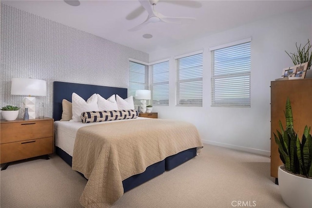 bedroom with wallpapered walls, multiple windows, baseboards, and light carpet