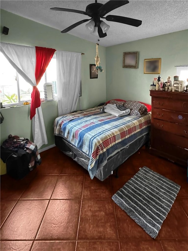 tiled bedroom featuring a textured ceiling and a ceiling fan