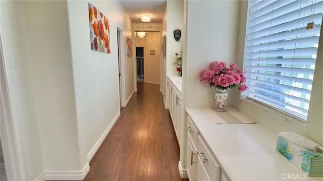 hallway featuring baseboards and wood finished floors