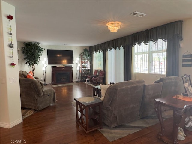 living area featuring visible vents, baseboards, wood finished floors, and a fireplace