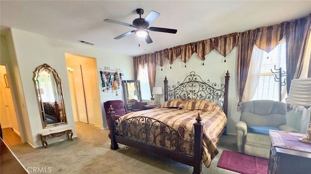 carpeted bedroom with visible vents, ceiling fan, and multiple windows