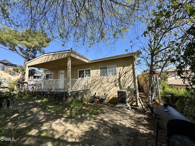 exterior space featuring stucco siding, a porch, and central AC