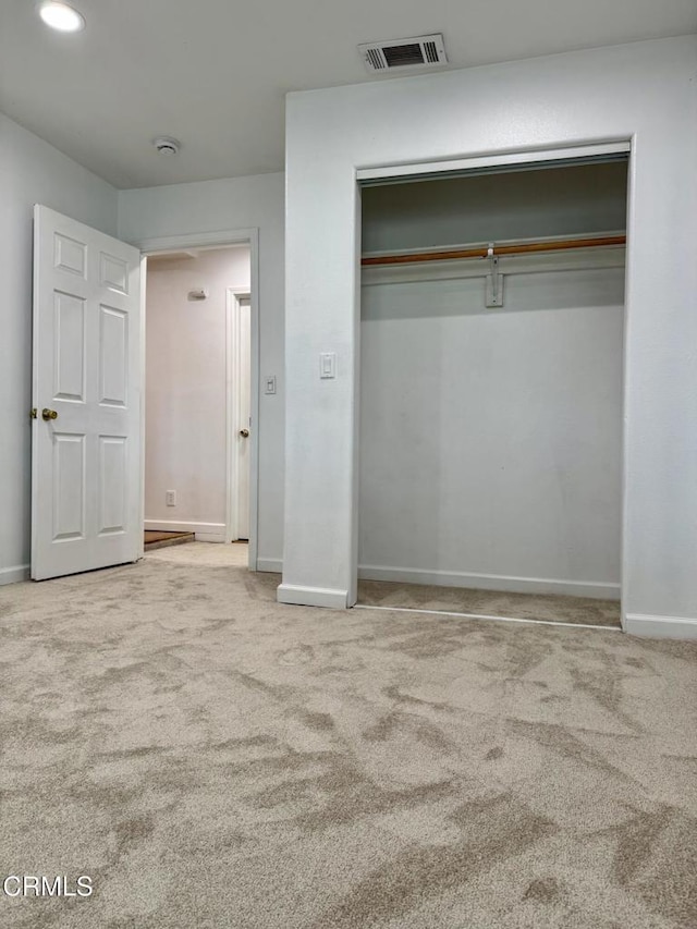 unfurnished bedroom featuring a closet, baseboards, visible vents, and carpet flooring