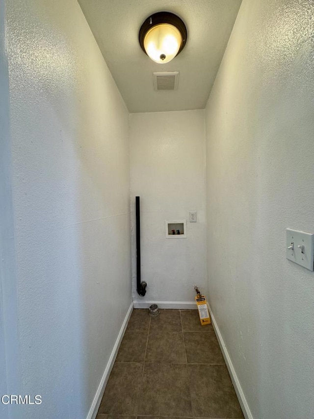 washroom featuring hookup for a washing machine, baseboards, visible vents, laundry area, and dark tile patterned flooring