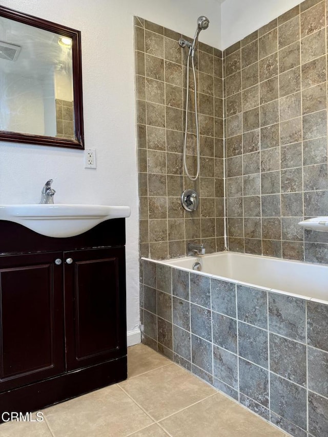 bathroom featuring tile patterned floors, visible vents, vanity, and tiled shower / bath