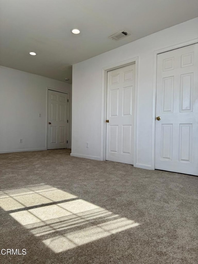 empty room featuring recessed lighting, carpet, visible vents, and baseboards