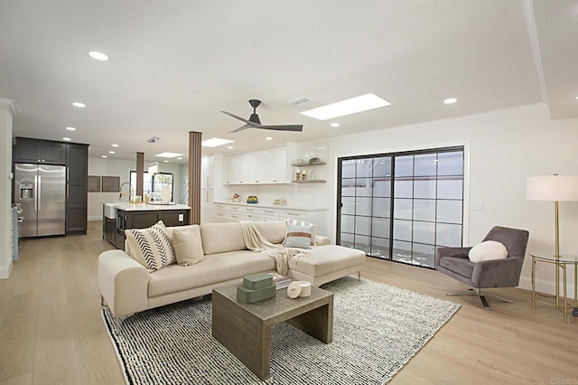 living room featuring crown molding, recessed lighting, a ceiling fan, and light wood-type flooring